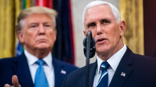 File - Then-President Donald J. Trump listens to then-Vice President Mike Pence speak in the Oval Office at the White House on Oct 8, 2019, in Washington, DC.