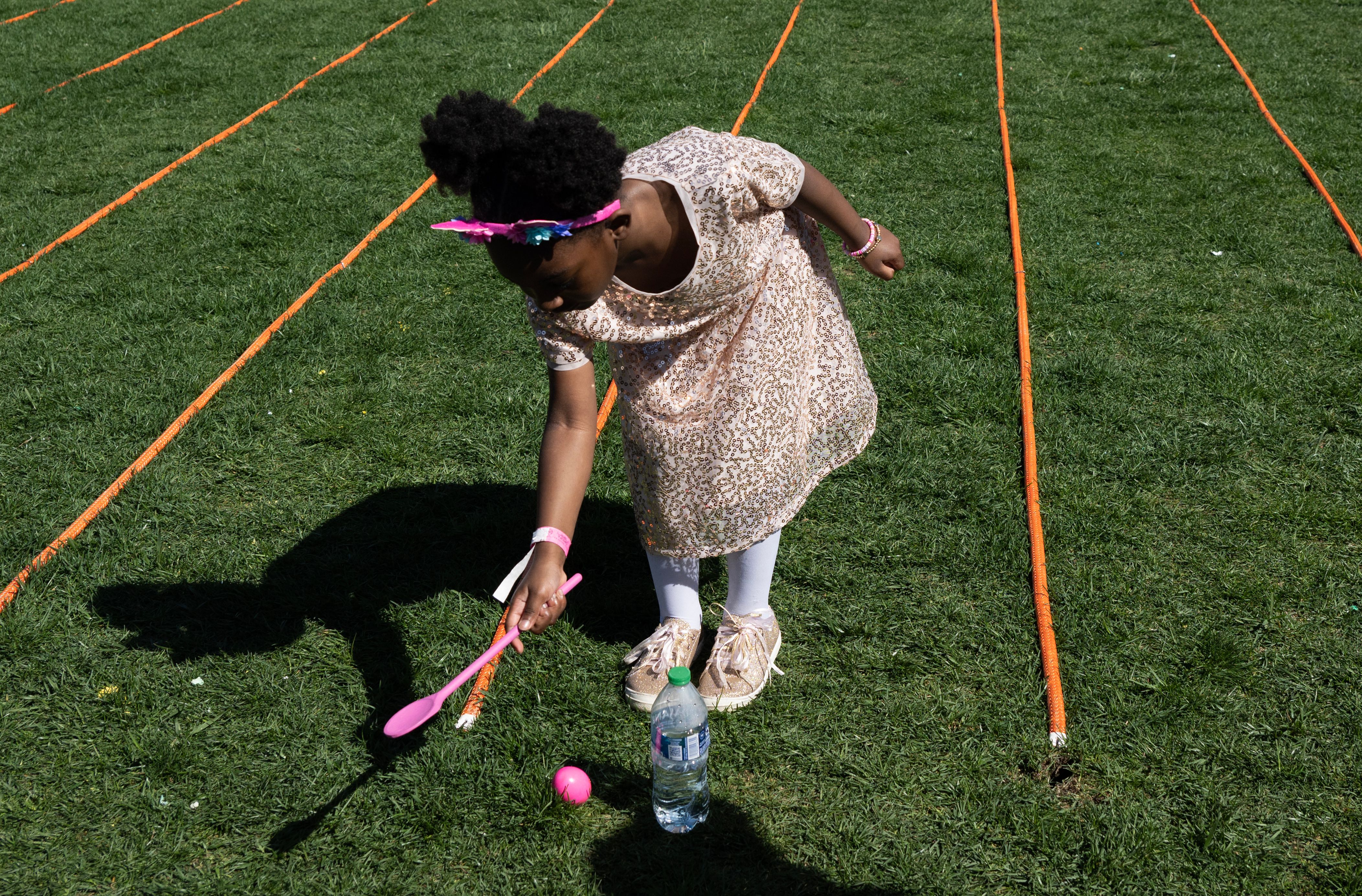 A child pushes an egg at the annual Easter Egg Roll on the South Lawn of the White House in Washington, D.C, April 10, 2023.