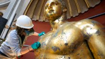 Vatican Museum restorer Alice Baltera works on restoring the bronze Hercules statue, in the Round Hall of the Vatican Museums, Thursday, May 11, 2023. 