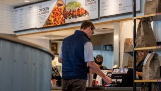 A customer pays for their food at a Chipotle Mexican Grill restaurant on April 26, 2023 in Austin, Texas.