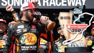 Martin Truex Jr., driver of the No. 19 Bass Pro Shops Toyota, drinks wine in victory lane after winning the NASCAR Cup Series Toyota / Save Mart 350 at Sonoma Raceway on June 11, 2023 in Sonoma, Calif.