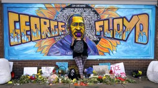 FILE – Damarra Atkins pays respect to George Floyd at a mural at George Floyd Square in Minneapolis, April 23, 2021. Two years after the U.S. Department of Justice launched an investigation of the Minneapolis Police Department in the wake of Floyd’s death, Attorney General Merrick Garland will be in Minneapolis on Friday, June 16, 2023, “on a civil rights matter.” DOJ spokeswoman Dena Iverson on Thursday, June 15, declined to say if the police department investigation will be the subject of the news conference at the federal courthouse in Minneapolis. (AP Photo/Julio Cortez, File)