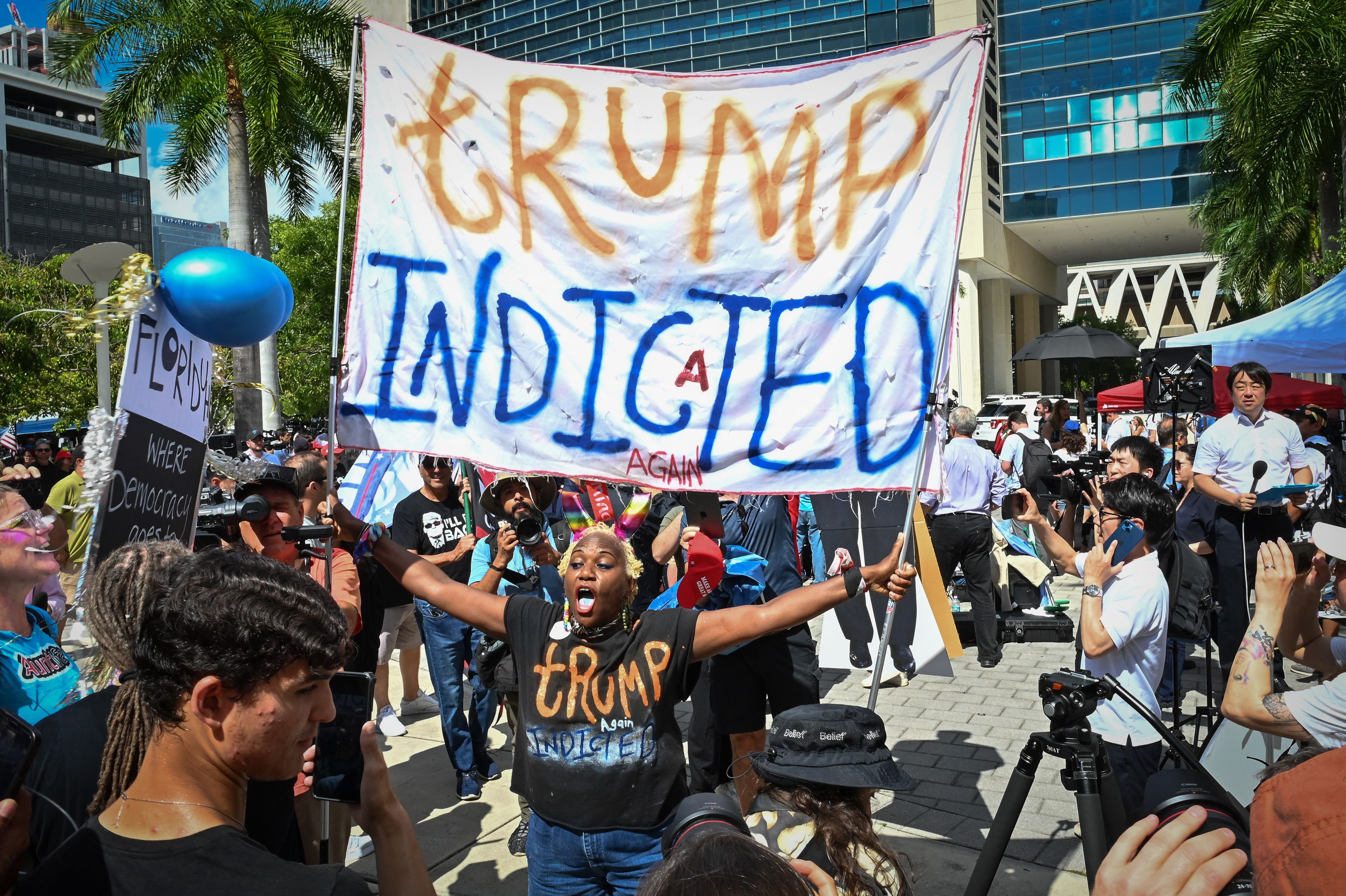 A protester holds a sign in front of the Wilkie D. Ferguson Jr. United States Courthouse before the arraignment of former President Donald Trump in Miami, June 13, 2023.