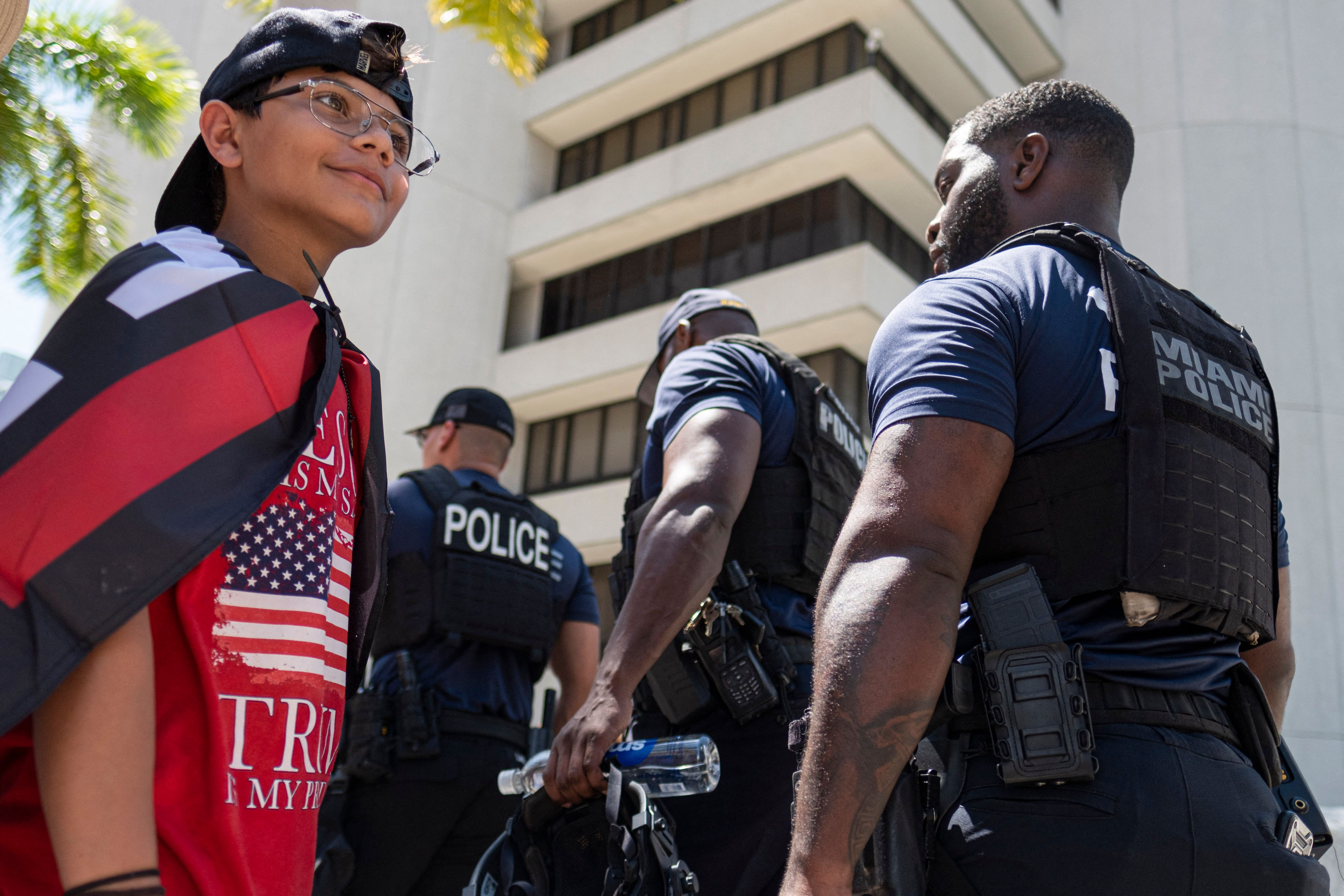 Miami police officers walk past onlookers gathered outside the Wilkie D. Ferguson Jr. United States Federal Courthouse in Miami, June 13, 2023.