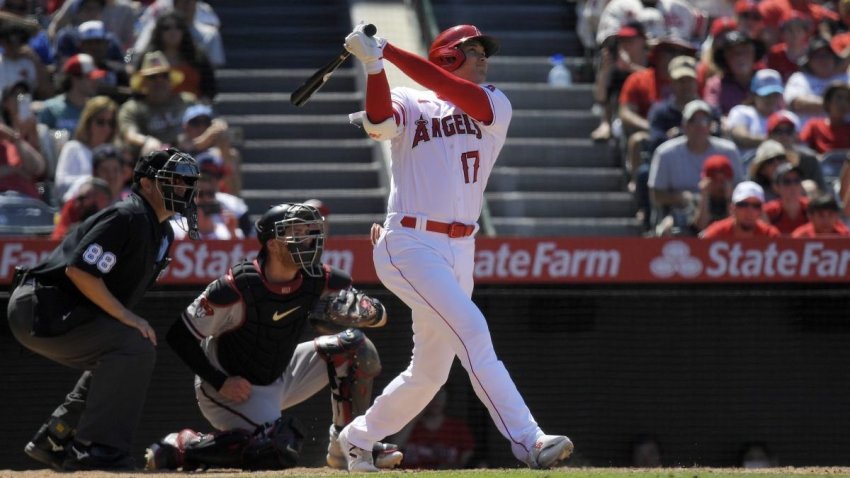 Los Angeles Angels’ Shohei Ohtani, right, hits a solo home run as Arizona Diamondbacks catcher Gabriel Moreno, center, and home plate umpire Doug Eddings watch during the eighth inning of a baseball game Sunday, July 2, 2023, in Anaheim, Calif. (AP Photo/Mark J. Terrill)