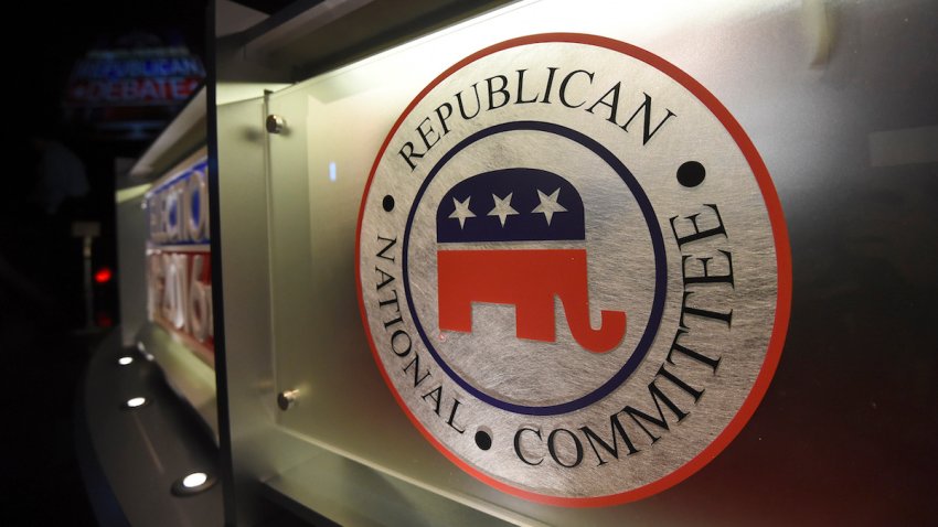 FILE – The Republican National Committee logo is shown on the stage as crew members work at the North Charleston Coliseum, Jan. 13, 2016, in North Charleston, S.C. With six weeks until the first 2024 Republican presidential debate, some hopefuls are finding creative ways to boost their donor numbers and ensure they make it on stage.