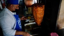 A cook prepares a taco with a Barbie themed pink tortilla at a restaurant in Mexico City, Thursday, July 20, 2023.