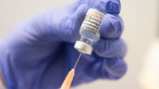 A staff member draws up a syringe with the Comirnaty vaccine from Biontech and Pfizer adapted to the Omicron-BA.1 variant at the Mainz vaccination center.