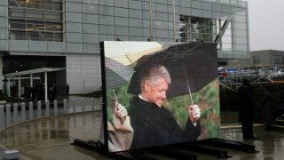 Former President Bill Clinton, by way of video monitor at the William J. Clinton Presidential Center during opening ceremonies in Little Rock, Ark., Nov. 18, 2004