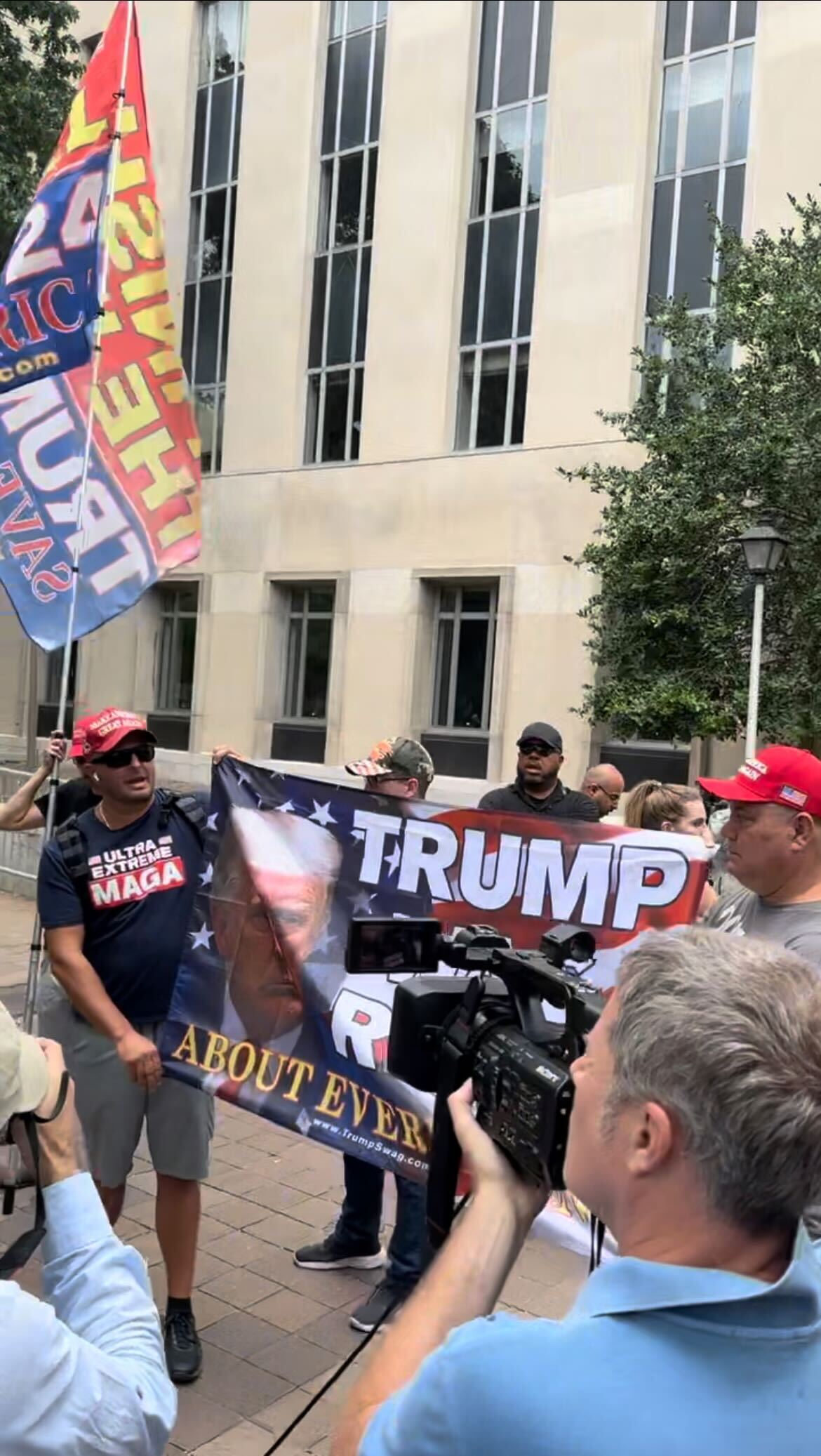 Trump supporters hold a sign that reads “Trump was right about everything” and talk to reporters about what they called a “rigged election” ahead of Trump’s arraignment in D.C. on Aug. 3, 2023.