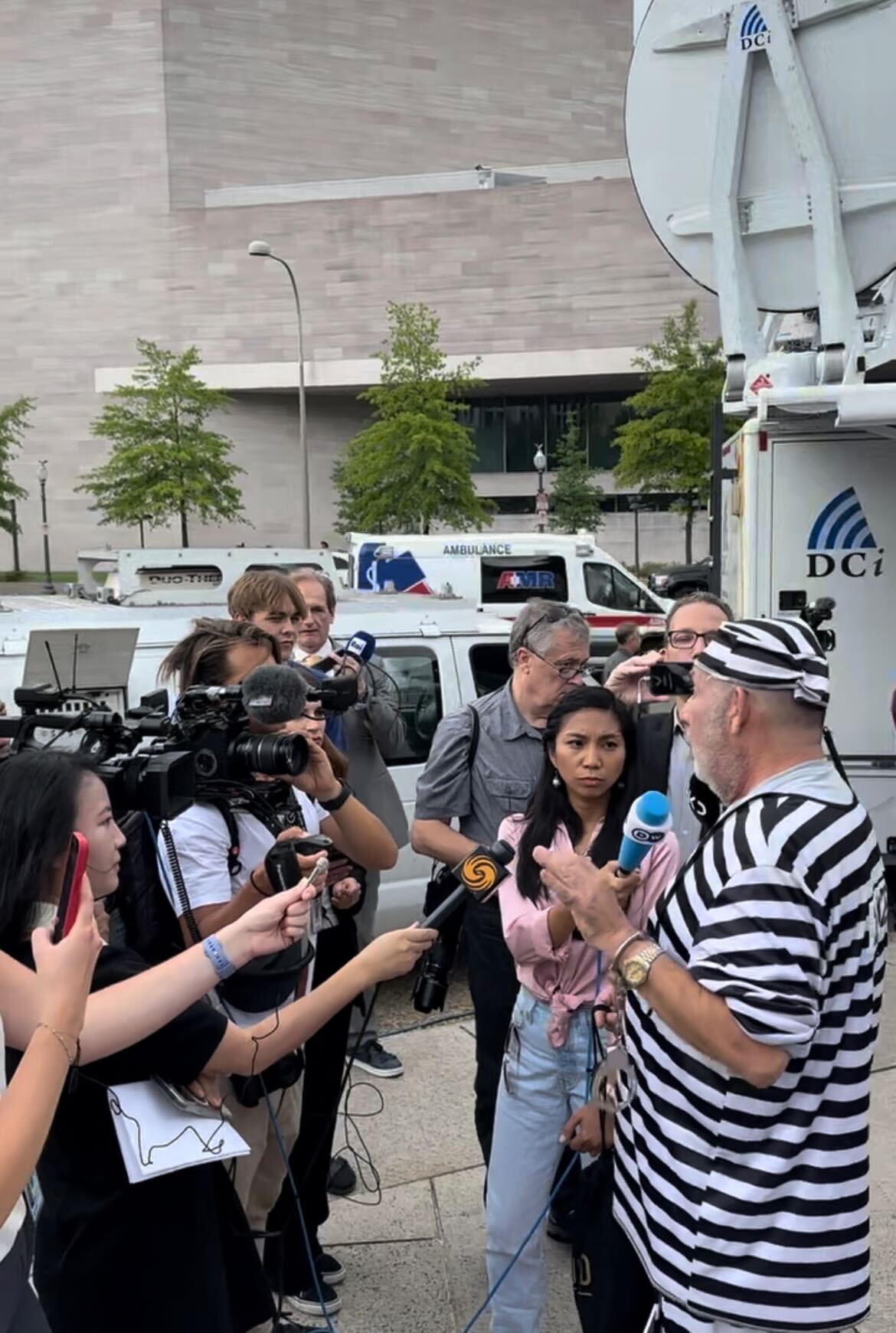 A swarm of reporters talk to an anti-Trump protestor on Aug. 3, 2023. Large crowds of spectators and protestors swarmed outside the courthouse where former President Donald Trump was arraigned on charges of election interference.