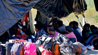 A group of men detained by U.S. Customs and Border Patrol after crossing the border wall in the Tucson Sector of the U.S.-Mexico border, are processed at a makeshift intake center, Tuesday, Aug. 29, 2023.