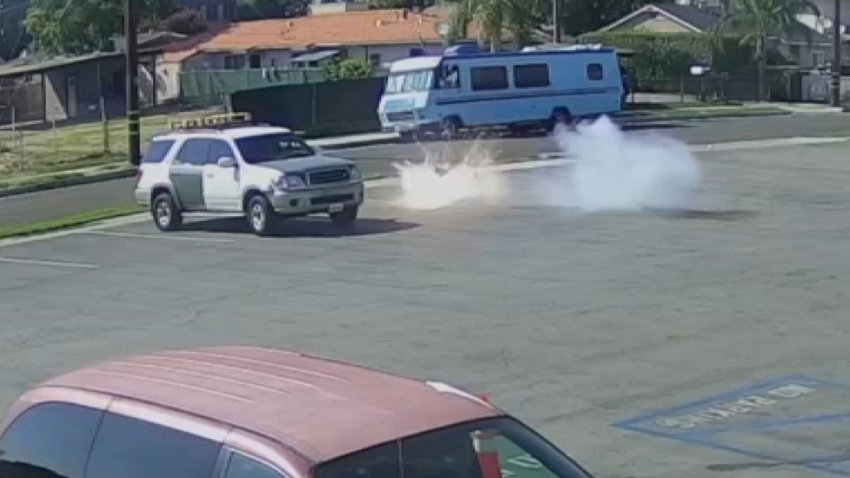 A teddy bear explodes next to an SUV in a parking lot.