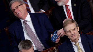 Former Speaker of the House Kevin McCarthy (R-CA) laughs at something he saw on his mobile phone and hands the phone off to Rep. Derrick Van Orden (R-WI) as they sit behind U.S. Rep. Jim Jordan (R-OH), the top contender in the race to be the next Speaker of the U.S. House of Representatives, during the first round of voting for a new Speaker on the floor of the House of Representatives at the U.S. Capitol in Washington, October 17, 2023.