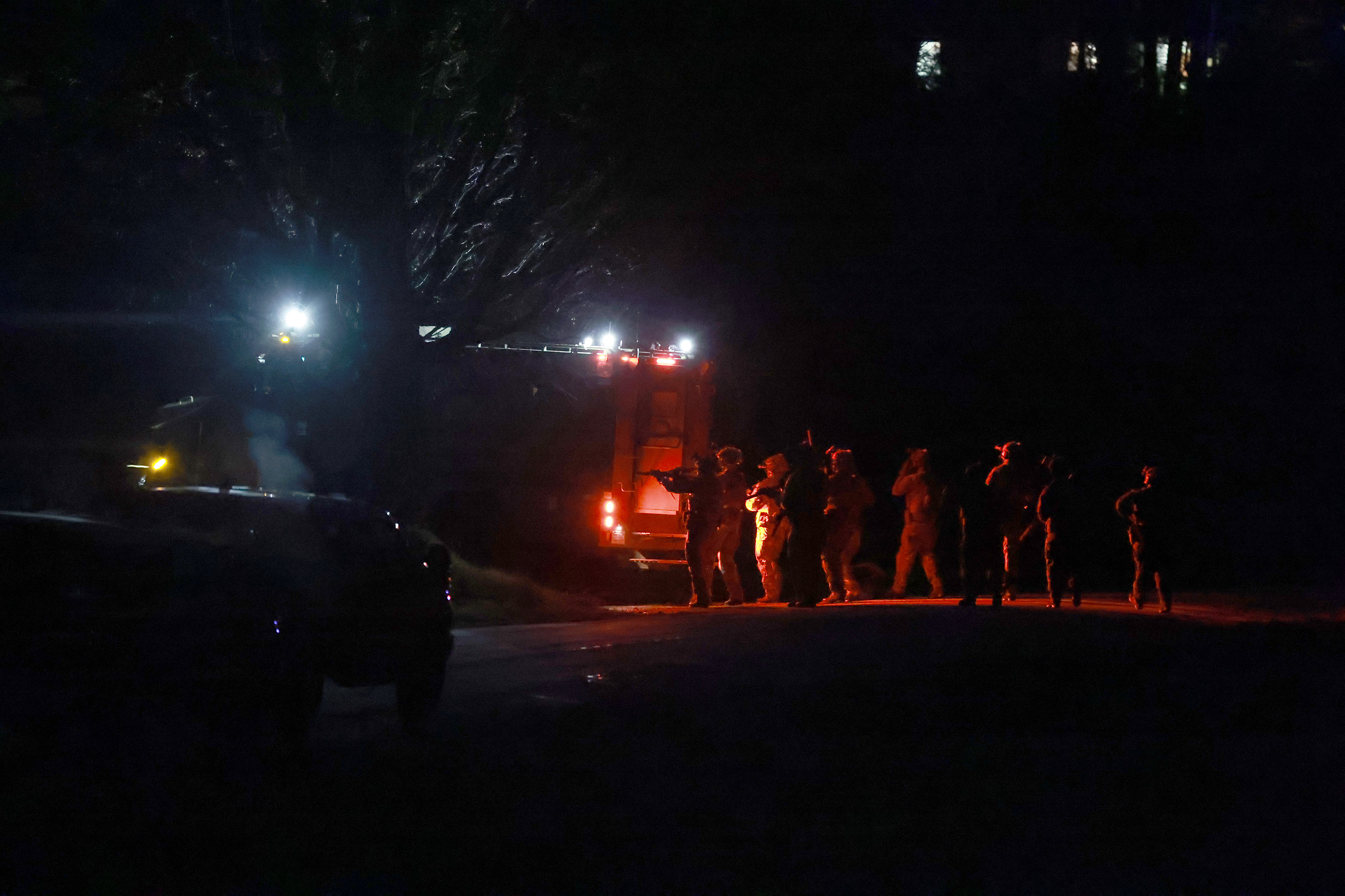 Law Enforcement officials gather near a home as they prepare to search it for the suspect in connection with two mass shootings on Thursday, Oct. 26, 2023 in Bowdoin, Maine.