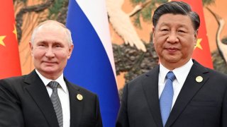 This pool photograph distributed by Russian state owned agency Sputnik shows Russia’s President Vladimir Putin and Chinese President Xi Jinping posing during a meeting in Beijing on October 18, 2023.