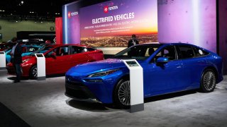 A 2022 Toyota Mirai hydrogen fuel cell vehicle, right, next to Toyota Prius hybrid vehicles during AutoMobility LA ahead of the Los Angeles Auto Show in Los Angeles, California, U.S., on Wednesday, Nov. 17, 2021.