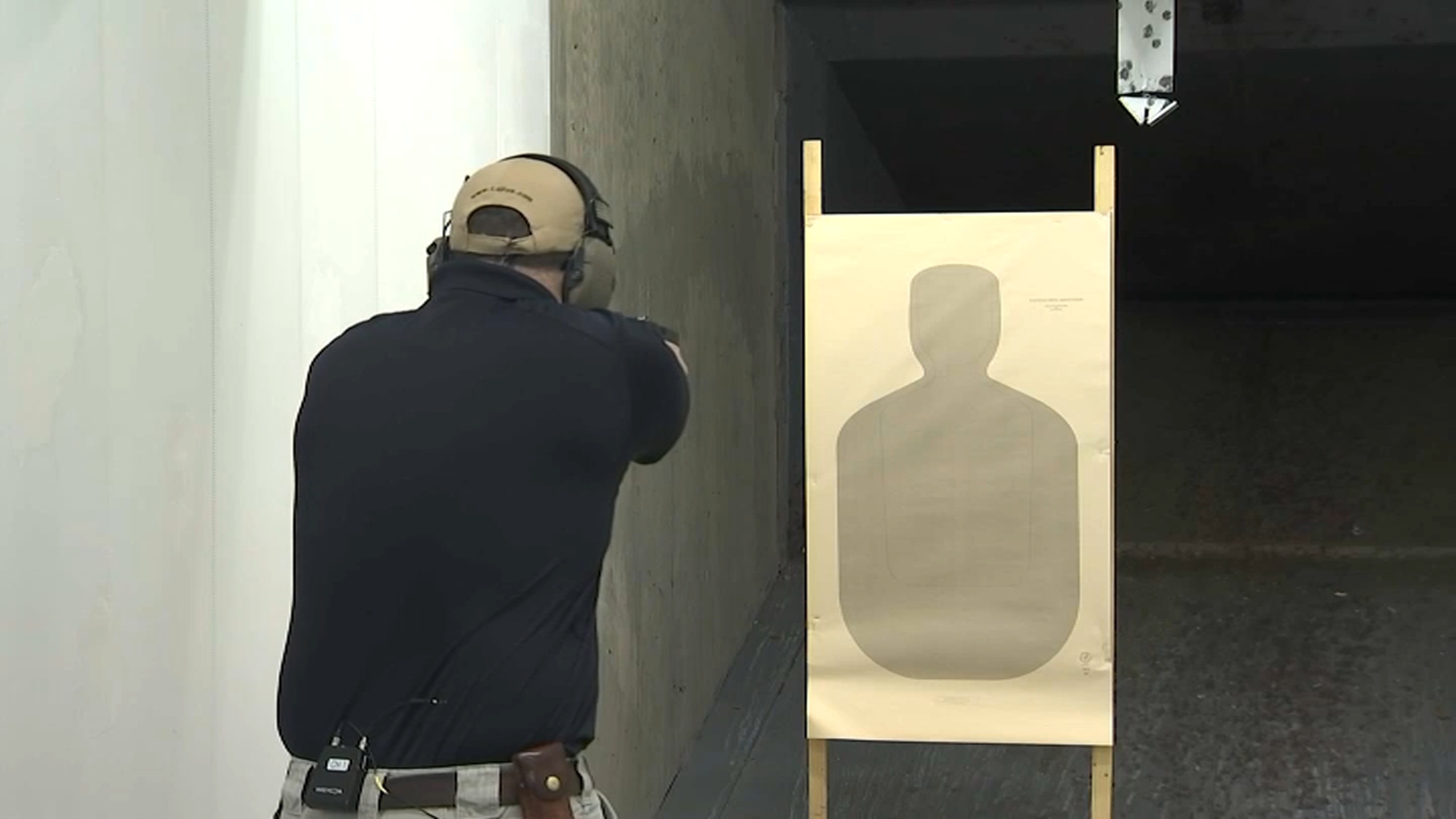 An agent fires shots with a Glock switch handgun at an ATF firing range.