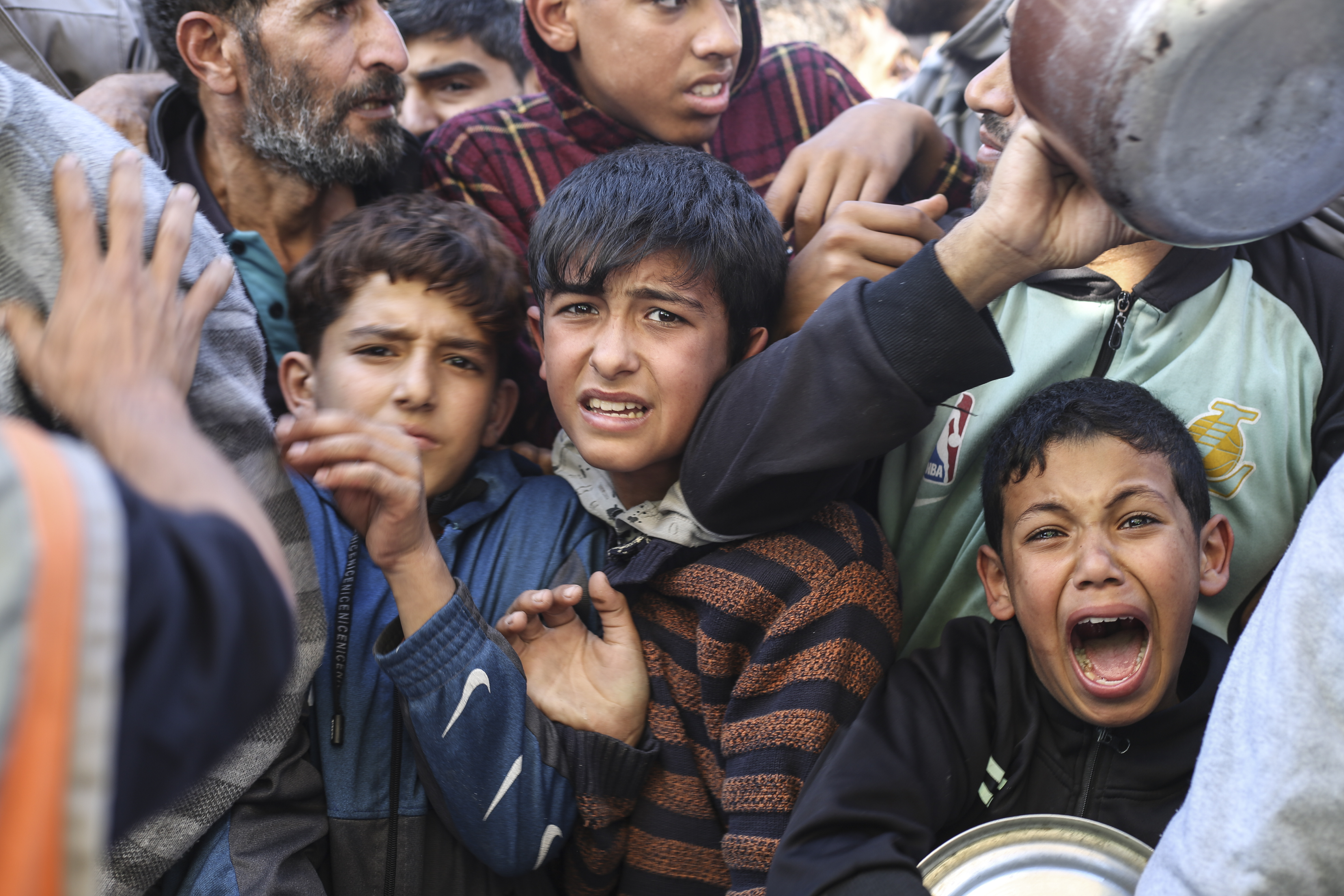 Palestinians line up for food in Rafah, Gaza Strip, Thursday, Nov. 30, 2023, during a temporary ceasefire between Israel and Hamas.