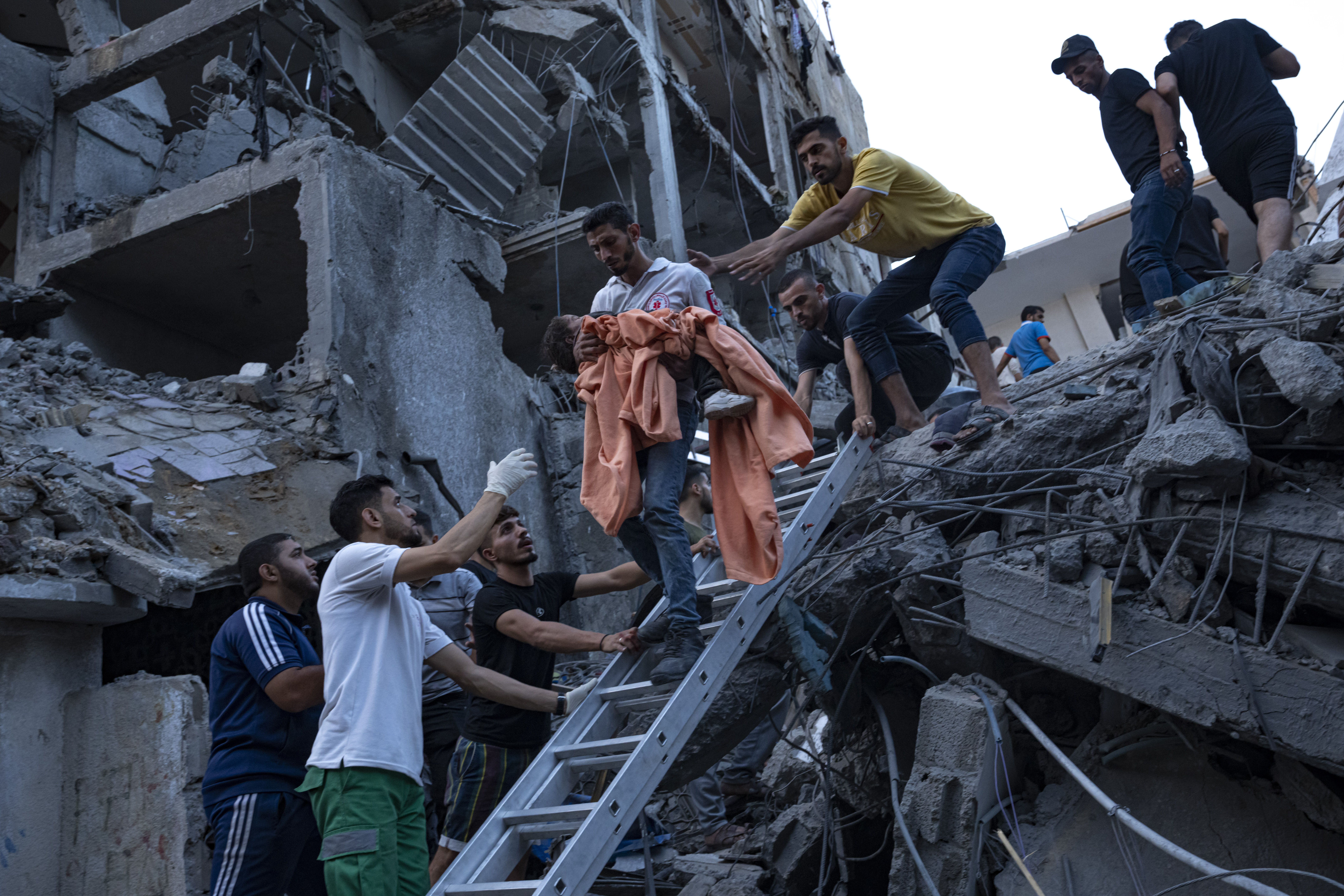 Palestinians rescue a young girl from the rubble of a destroyed residential building following an Israeli airstrike, Tuesday, Oct. 10, 2023.