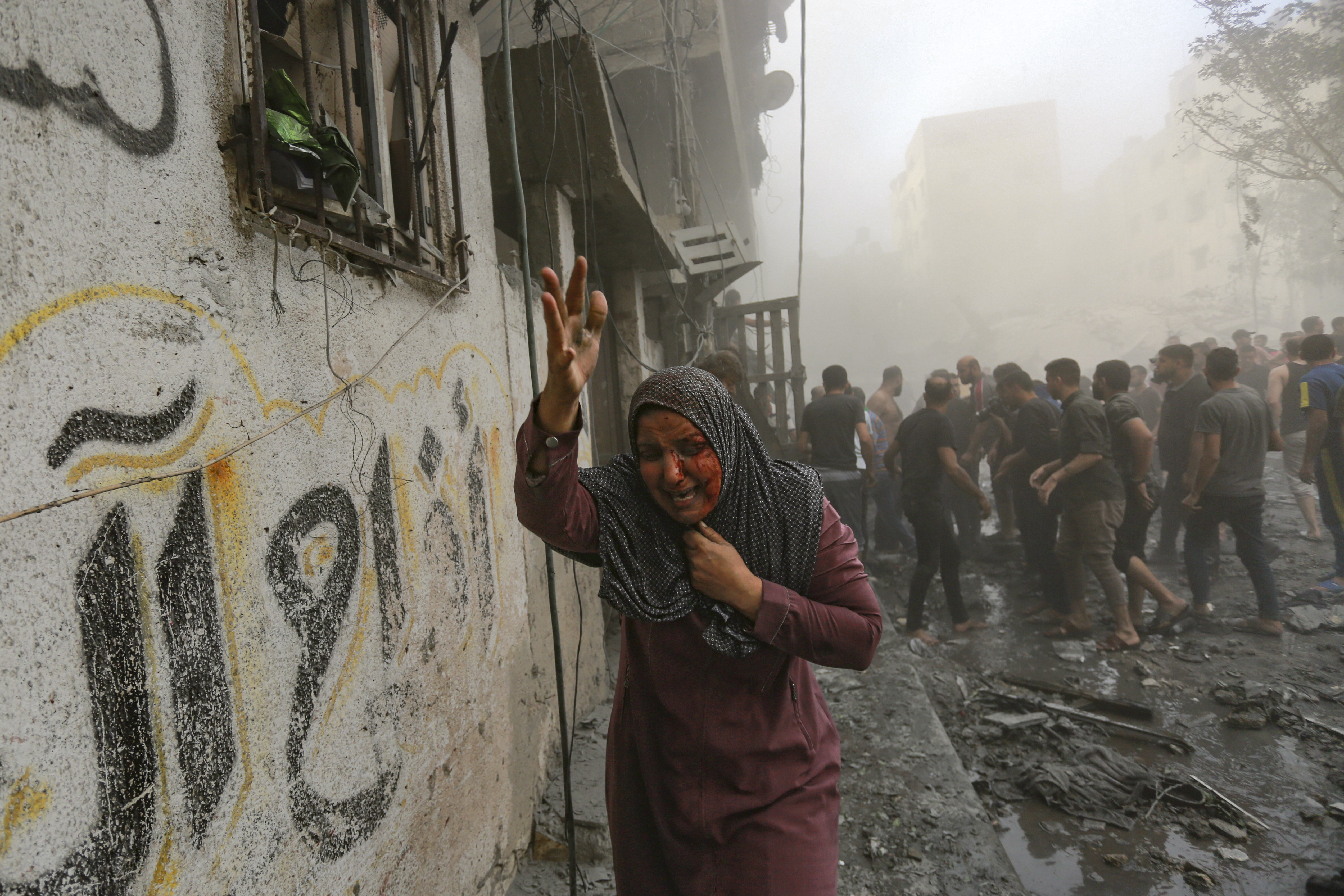 A wounded Palestinian woman runs following Israeli airstrikes that targeted her neighborhood in Gaza City, Monday, Oct. 23, 2023.