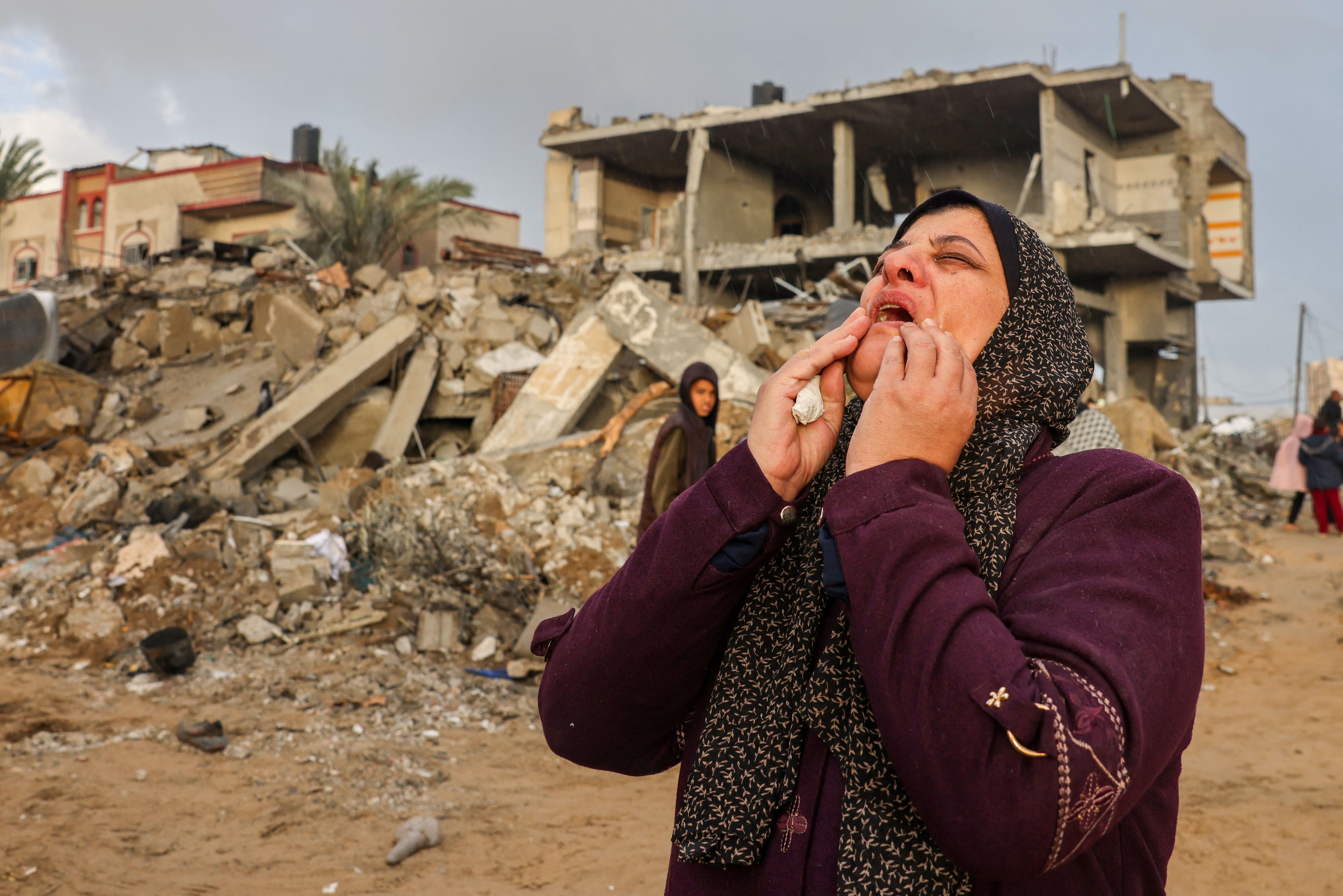 A Palestinian woman reacts as people inspect the damage following Israeli strikes on Rafah, on the southern Gaza Strip, on November 20, 2023, amid continuing battles between Israel and the militant group Hamas.