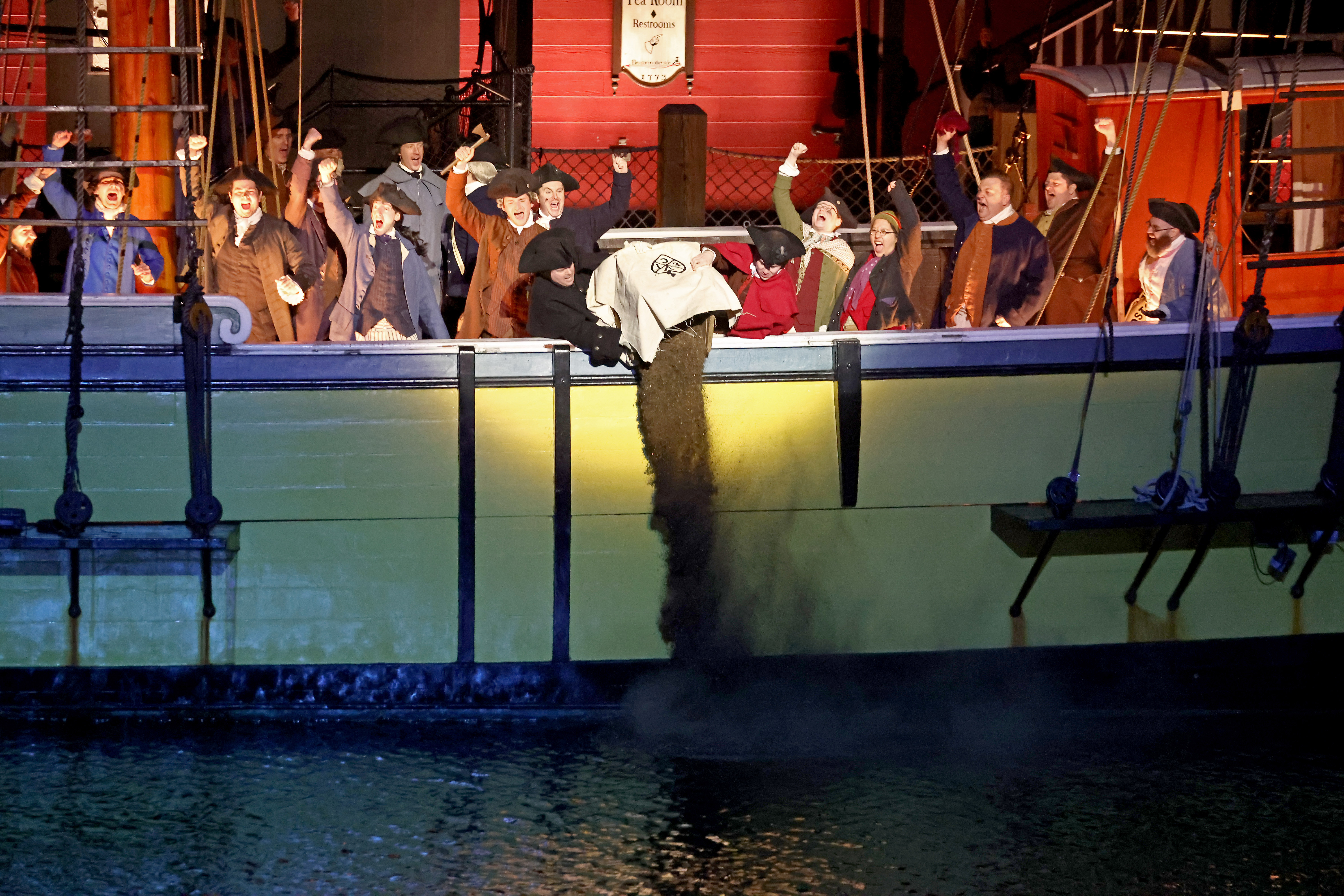 Re-enactors dump tea into the harbor as Boston celebrates the 250th anniversary of the Boston Tea Party on Saturday, Dec. 16, 2023.