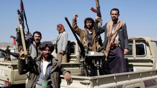 Houthi followers lift rifles and shout slogans against the U.S.-U.K. during a tribal gathering on January 14, 2024 on the outskirts of Sana’a, Yemen.