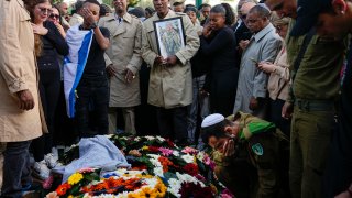 FILE - Family and friends of Staff Sergeant Aschalwu Sama mourn over his grave during his funeral in Petah Tikva, Israel, Sunday, Dec. 3, 2023. Sama, 20, died of his wounds after he was injured in a ground operation in the Gaza Strip. Now 100 days old, the latest Israel-Hamas war is by far the longest, bloodiest, and most destructive conflict between the bitter enemies. The fighting erupted on Oct. 7, 2023 when Hamas carried out a deadly attack in southern Israel. Since then, Israel has relentlessly pounded the Gaza Strip with airstrikes and a ground offensive that have wrought unprecedented destruction, flattening entire neighborhoods.