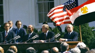 FILE – U.S. President Jimmy Carter, Egyptian President Anwar Sadat and Israeli President Menachem Begin attend the formal ceremony for the Camp David Accords in Washington, D.C., March 26, 1979, designed to bring peace to the Middle East.