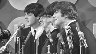 FILE - The Beatles address the media in the press room of Kennedy International Airport on their arrival, Feb. 7, 1964, in New York.