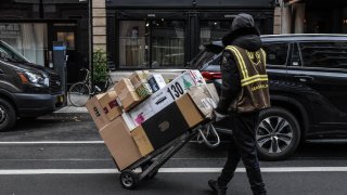 A UPS seasonal worker delivers packages on Cyber Monday in New York on Nov. 27, 2023.