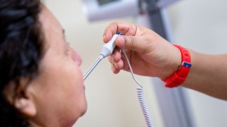 A medical assistant takes a patient's temperature