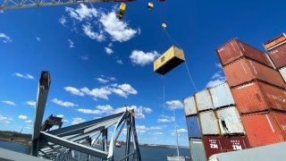 A Key Bridge Response 2024 Unified Command image of response crews remove shipping containers using a floating crane barge after the cargo ship Dali struck and collapsed the Francis Scott Key Bridge, on April 7, 2024 in Baltimore, Maryland.