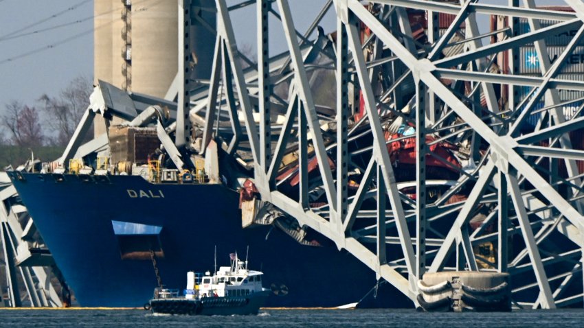 The collapsed Francis Scott Key Bridge lies on top of the container ship Dali in Baltimore, Maryland, on March 29, 2024, as clean-up work begins.. Cranes began arriving March 28 at the scene of the catastrophic bridge collapse over Baltimore harbor, as authorities shifted to a clean-up phase of the recovery and warned of extensive work before the major US port can reopen. Four men, all Latin American immigrants, are believed to have been killed when the Singapore-flagged container ship lost power and careened into a bridge support column. (Photo by Mandel NGAN / AFP) (Photo by MANDEL NGAN/AFP via Getty Images)