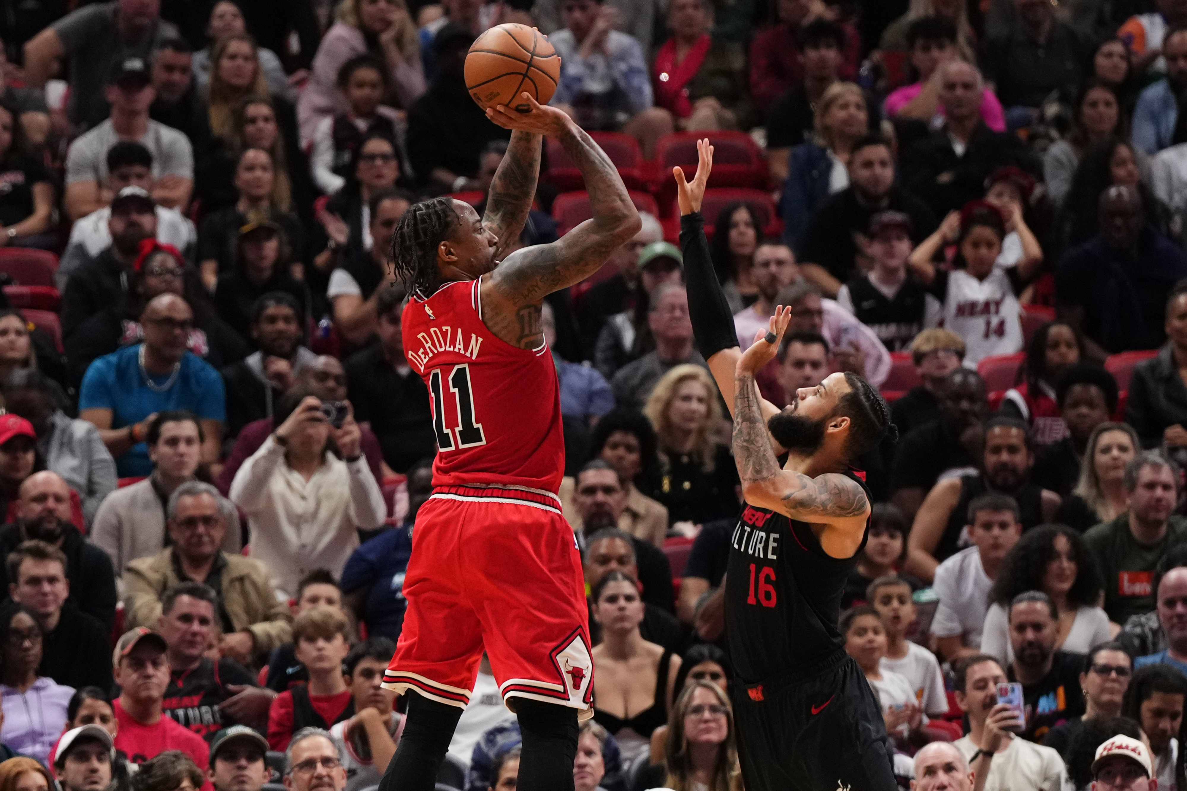 Dec 16, 2023; Miami, Florida, USA; Chicago Bulls forward DeMar DeRozan (11) shoots over Miami Heat forward Caleb Martin (16) during the second half at Kaseya Center. Mandatory Credit: Jasen Vinlove-USA TODAY Sports