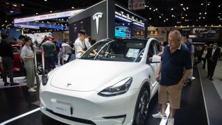 Visitors inspect a Tesla Model Y car during the 40th Thailand International Motor Expo at the Impact Challenger hall in Nonthaburi.