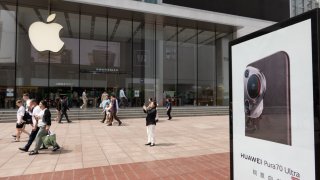 An advertisement for the Huawei Pura70 mobile phone is being seen in front of the Apple Store on the pedestrian street of Nanjing Road in Shanghai, China, on May 15, 2024.