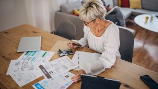 Woman at home looking at the bills and taxes. 