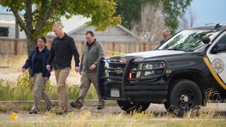 FILE – Authorities walk outside a closed funeral home where multiple bodies have been stored, Friday, Oct. 6, 2023, in Penrose, Colo. Colorado lawmakers passed a sweeping bill Monday, May 6, 2024.