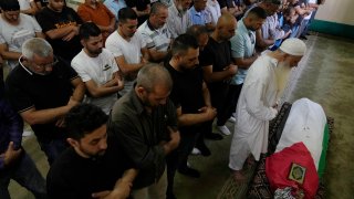 Palestinian mourners pray at the body of Mohammad Hoshiya, 12, during his funeral in the West Bank village of Qatana, southwest of Ramallah Saturday, June 22, 2024. The Palestinian Health Ministry said  Hoshiya died from his wounds after being shot by Israeli forces in Ramallah last week.