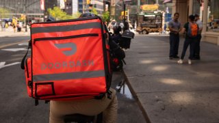 A delivery worker carries a DoorDash bag in New York, US, on Monday, April 29, 2024.