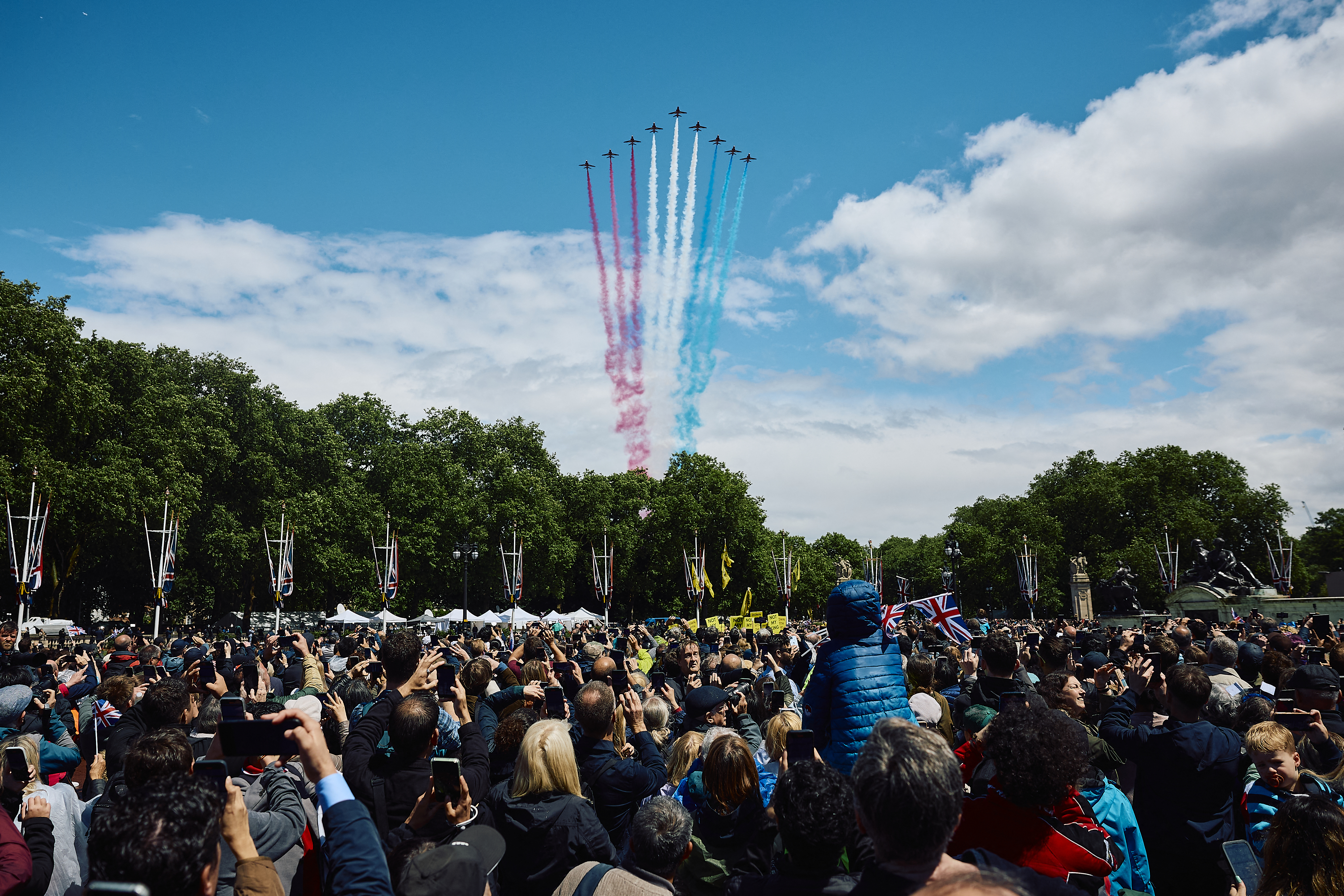 Members of the public watch as the British Royal Air Force’s (RAF) aerobatic team, the “Red Arrows” perform a flypast over Buckingham Palace during the King’s Birthday Parade “Trooping the Colour” in London on June 15, 2024.