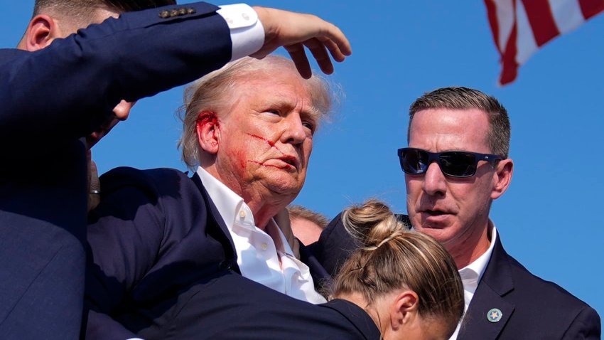 Republican presidential candidate former President Donald Trump is surrounded by U.S. Secret Service agents as he leaves the stage at a campaign rally, Saturday, July 13, 2024, in Butler, Pa.