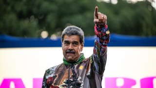 President of Venezuela Nicolas Maduro rises his hand during a mass gathering convene by supporters on July 18, 2024 in Caracas, Venezuela.