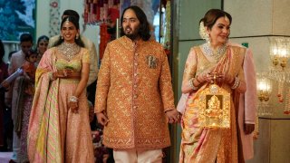 Billionaire Mukesh Ambani’s son Anant Ambani, center, stands with mother Nita Ambani, right, and sister Isha Piramal Ambani at his and Radhika Merchant’s wedding at Jio World Convention Centre in Mumbai, India, Friday, July 12, 2024.