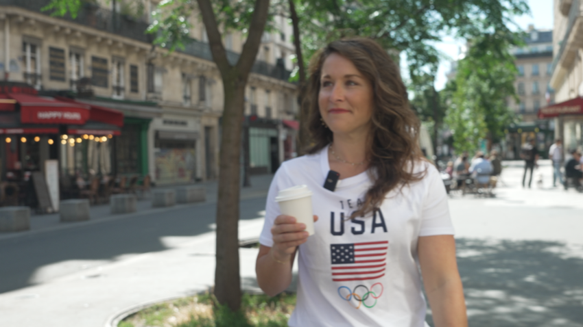 Carly Patterson walks with cup of coffee