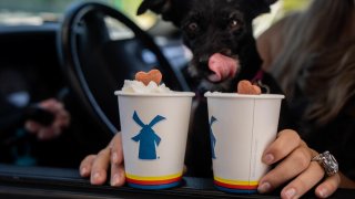 A customer receives dog treat drinks at the drive-through window of a Dutch Bros. Coffee location in Beaverton, Oregon, U.S., on Thursday, June 24, 2021.