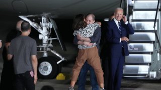 Evan Gershkovich greets his mother Ella Milman after he arrived back in the United States as President Joe Biden looks on on Aug. 1, 2024 at Joint Base Andrews, Maryland.