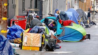 Homeless people consume illegal drugs in an encampment along Willow St. in the Tenderloin district of downtown on Thursday, Feb. 24, 2022 in San Francisco, CA. 